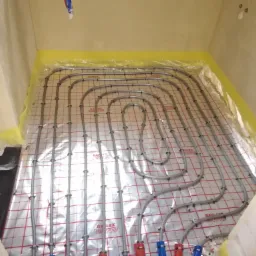 Rozłożona instalacja ogrzewania podłogowego z rur Reflex Term System w Skórzewie, widok z góry przed zalaniem wylewką.