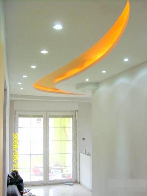 Oryginalny sufit napinany z podświetleniem LED w kształcie fali, widoczny w pomieszczeniu w Jaworznie. Nowoczesny design i subtelne oświetlenie.