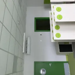 Klimatyzator zamontowany na ścianie w pomieszczeniu w Wąsoszu, widoczny zielony akcent kolorystyczny drzwi i ramy okiennej.