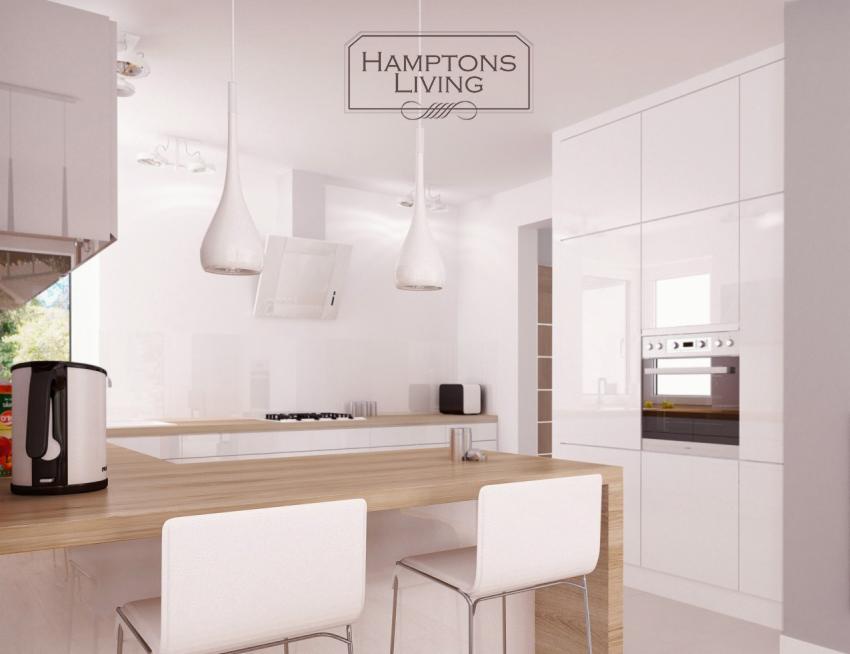 Jasna kuchnia w stylu Hamptons Living, Warszawa. Białe, lakierowane fronty szafek, drewniany blat i wiszące lampy tworzą elegancką, minimalistyczną przestrzeń.