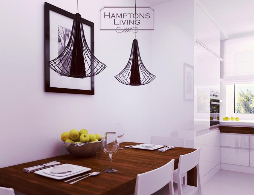 Nowoczesna jadalnia z drewnianym stołem, białymi krzesłami i designerskimi lampami wiszącymi. Na stole owoce i zastawa. W tle białe meble kuchenne.