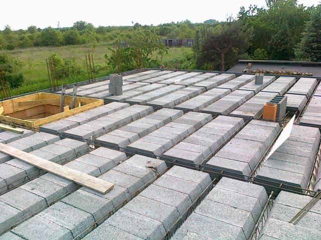 Budowa stropu Teriva: prefabrykowane belki i pustaki betonowe na budowie domu jednorodzinnego, widoczny szalunek otworu w stropie.