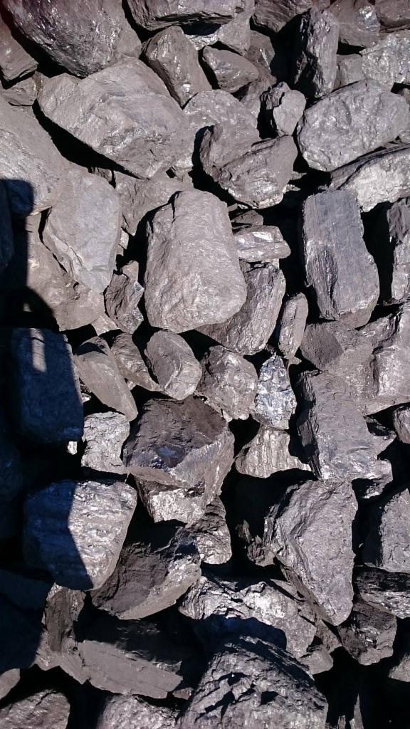 Kupa brył węgla orzech, o nieregularnych kształtach, z widocznymi refleksami światła na powierzchniach.