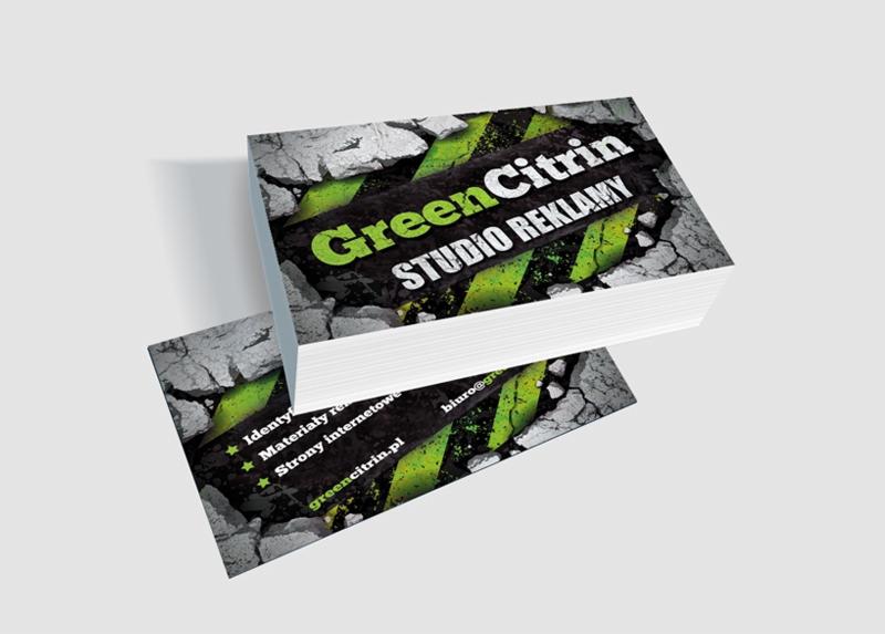 Stos wizytówek GreenCitrin Studio Reklamy z motywem pęknięć i zielonych pasów. Widoczne dane kontaktowe i zakres usług: identyfikacja, materiały reklamowe, strony internetowe.