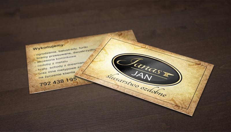 Dwie wizytówki ślusarstwa ozdobnego 'Janas Jan' na drewnianym tle. Jedna z numerem telefonu, druga z logo firmy w owalu.