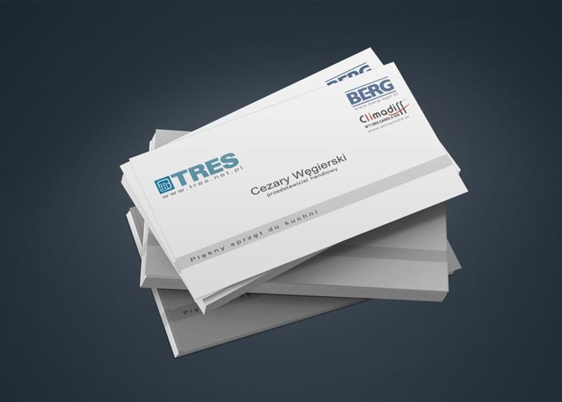 Stos wizytówek z logo TRES i BERG na ciemnym tle. Wizytówki przedstawiają Cezarego Węgierskiego, przedstawiciela handlowego sprzętu do kuchni. Minimalistyczny design.