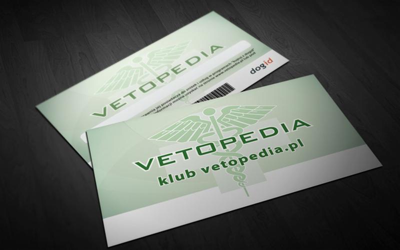 Dwie karty rabatowe Vetopedia.pl w odcieniach zieleni z symbolem Eskulapa, leżące na ciemnym, drewnianym tle. Jedna z kart ma pasek z kodem kreskowym.