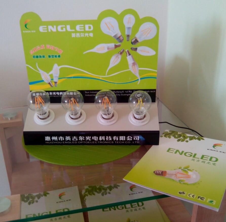 Prezentacja żarówek LED marki Engled na ekspozytorze z zielonymi elementami graficznymi. Widoczne cztery żarówki na białych podstawkach i ulotki reklamowe.