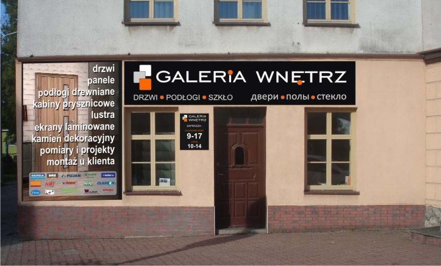 Fasada budynku z szyldem 'Galeria Wnętrz' oferująca drzwi, podłogi i szkło. Widoczne okna i brązowe drzwi wejściowe. Reklama z listą produktów i usług.