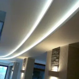 Nowoczesny sufit podwieszany z oświetleniem LED, dekoracyjne panele ścienne z kamienia, widok z dołu.