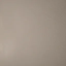 Beżowa, gładka powierzchnia ściany z delikatną fakturą, oświetlona z prawej strony, tworząca subtelny cień.