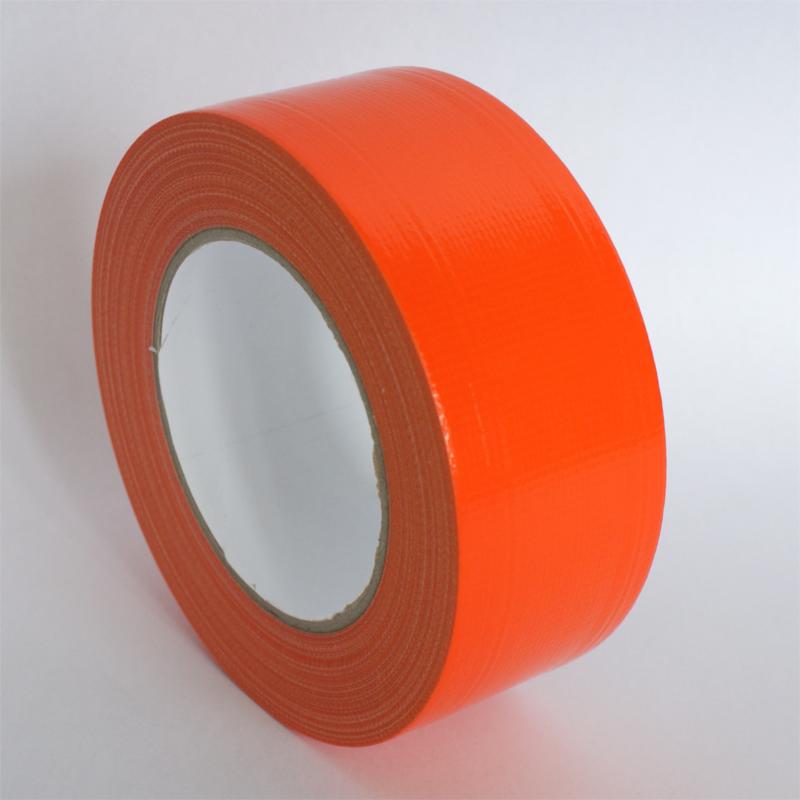 Pomarańczowa taśma tynkarska z wyraźną fakturą materiału, zwinięta w rolkę, leżąca na jasnym tle, z widocznym brązowym kartonowym rdzeniem.