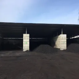 Zadaszony magazyn w Bobrownikach z pryzmami czarnego węgla, widoczne betonowe ściany z numerami 1 i 2.