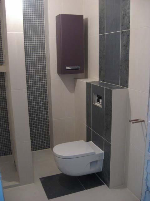 Nowoczesna łazienka z podwieszaną toaletą, szarą mozaiką i szafką w kolorze śliwki. Minimalistyczny design, neutralna kolorystyka, oświetlenie górne.