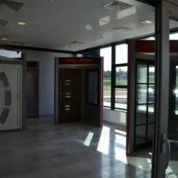 Ekspozycja drzwi i okien w salonie: różnorodne modele, od białych drzwi z przeszkleniami po ciemne, solidne drzwi z metalowymi akcentami, oraz okna z czarnymi szprosami.