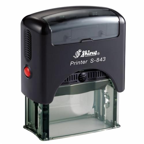 Automatyczna pieczątka firmowa Shiny Printer S-843 z czarną obudową i czerwonym przyciskiem, widoczna przezroczysta podstawa.