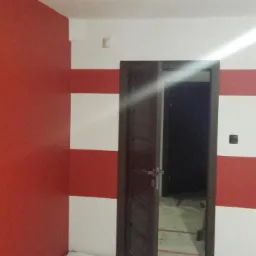 Pomieszczenie po malowaniu z poziomymi pasami czerwieni i bieli na ścianie, z otwartymi drewnianymi drzwiami i czerwoną ścianą po lewej stronie.