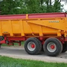 Pomarańczowa, dwuosiowa przyczepa wywrotka marki Pezzon podpięta do czerwonego ciągnika na asfaltowej drodze, otoczona zielenią. Widoczne duże opony i solidna konstrukcja przyczepy.