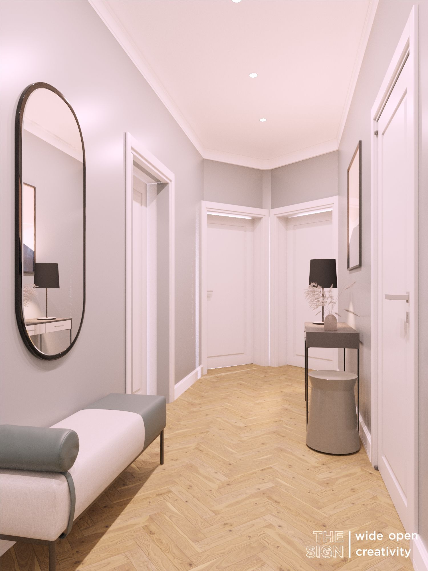 Nowoczesny przedpokój w odcieniach szarości i bieli z parkietem w jodełkę, wyposażony w ławkę z szarymi akcentami, owalne lustro w czarnej ramie oraz stolik z lampką.