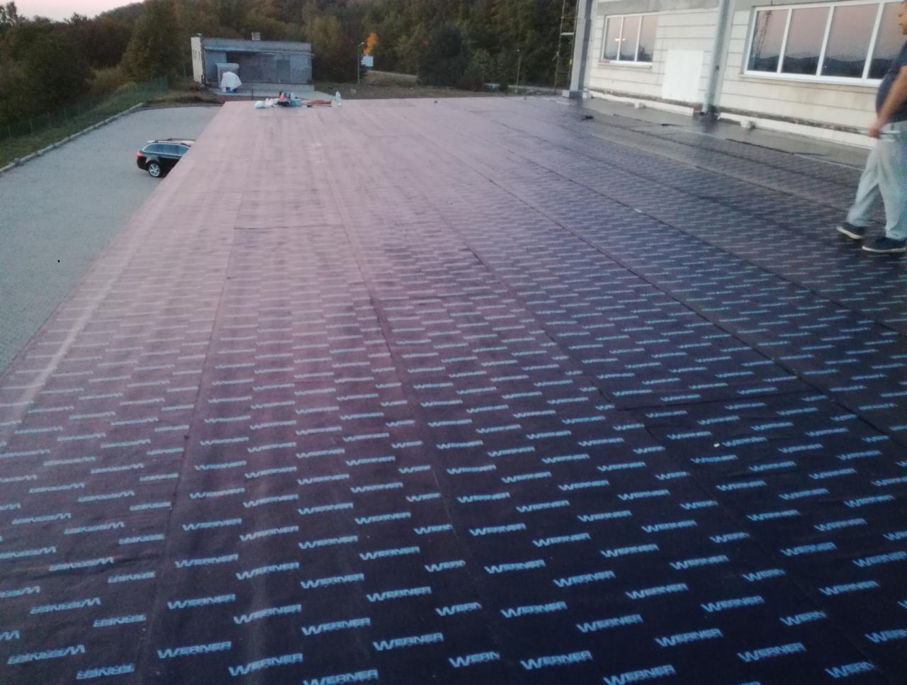 Hydroizolacja dachu płaskiego papą termozgrzewalną z logo producenta, widok z góry, Krokowa.