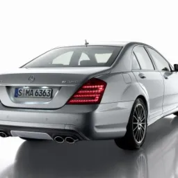 Srebrny samochód marki Mercedes-Benz S63 AMG, widok z tyłu, z widocznymi światłami i tablicą rejestracyjną S MA 6363, na białym tle.