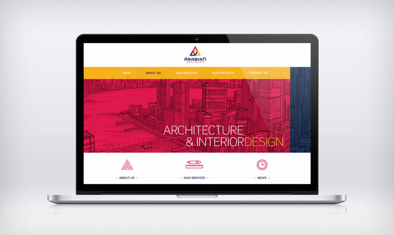 Ekran laptopa prezentuje stronę internetową firmy Arabian Designer z grafiką architektoniczną w odcieniach czerwieni i niebieskiego oraz hasłem ARCHITECTURE & INTERIOR DESIGN.