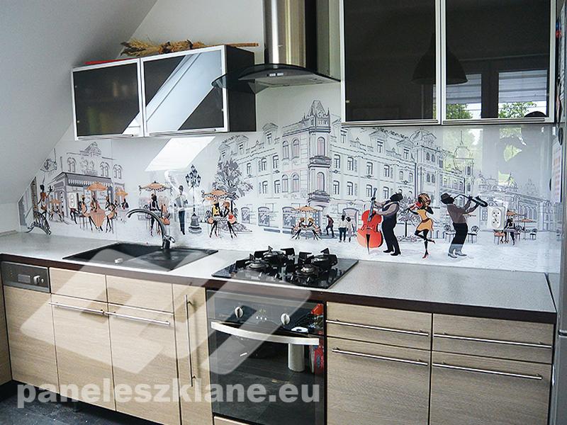 Szklany panel kuchenny z nadrukiem czarno-białej panoramy miasta i motywem muzycznym, zamontowany nad blatem z zabudową kuchenną w nowoczesnej kuchni.