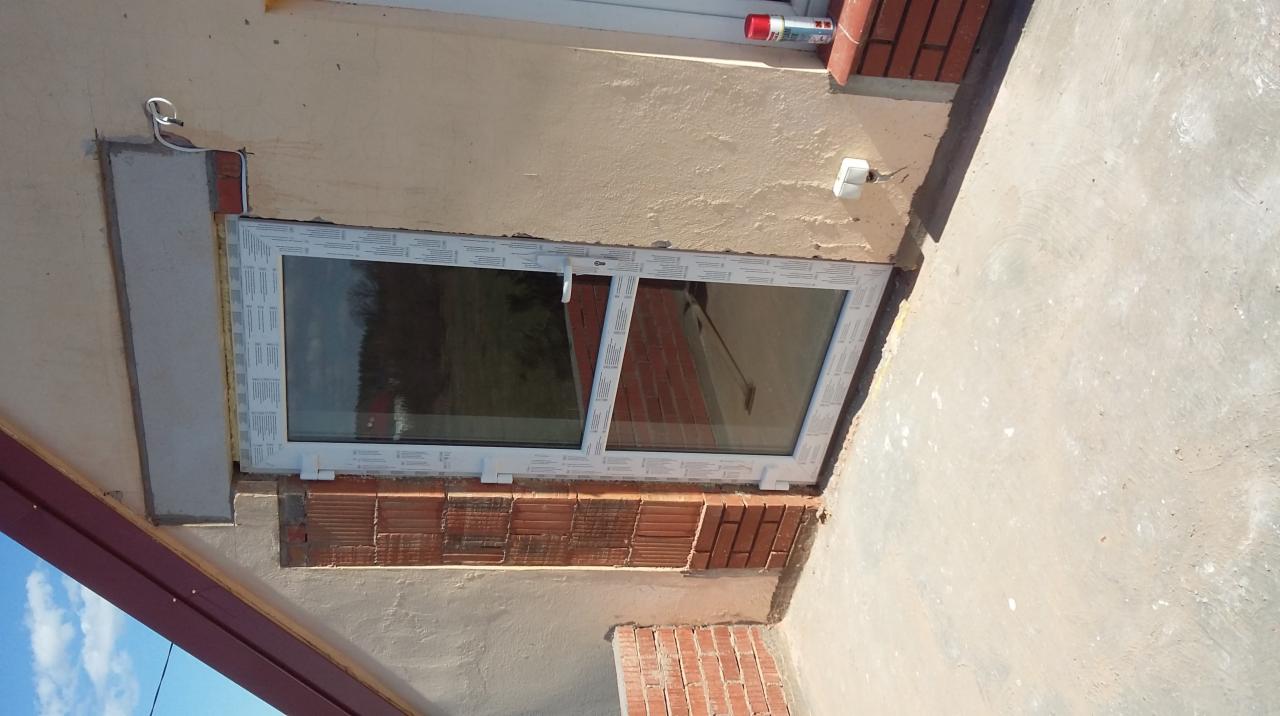 Montaż okna w murze z cegły, widoczne detale wykończenia. Usługi remontowe w Markach.