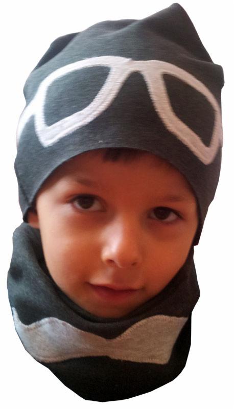 Chłopiec w szaro-białej czapce z motywem okularów i kominie. Ujęcie portretowe, skupione na twarzy dziecka. Produkt szyty na miarę, unikalny wzór.