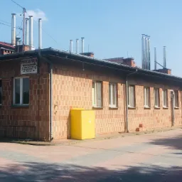 Budynek piekarni z cegły z wieloma kominami ze stali nierdzewnej na dachu, żółta szafka gazowa przy ścianie