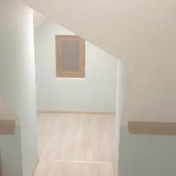 Poddasze po remoncie z drewnianą ramą okienną i wykończonymi skosami, widoczne drewniane elementy konstrukcyjne i podłoga imitująca panele.