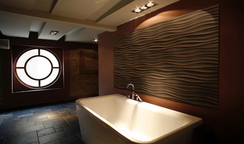 Nowoczesna łazienka z białą wanną, dekoracyjnym panelem ściennym i okrągłym oknem. Ciemna podłoga i oświetlenie punktowe nadają wnętrzu elegancki charakter.