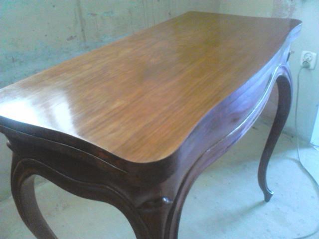 Odrestaurowany, drewniany stolik w stylu ludwikowskim z giętymi nogami. Blat po renowacji, z wyraźnym połyskiem. Widoczne detale snycerskie.