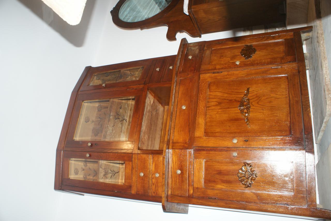 Antyczna, drewniana zabudowa balkonu z dekoracyjnymi szybkami i ornamentami, odnowiona z dbałością o detale, widoczna na tle białej ściany.