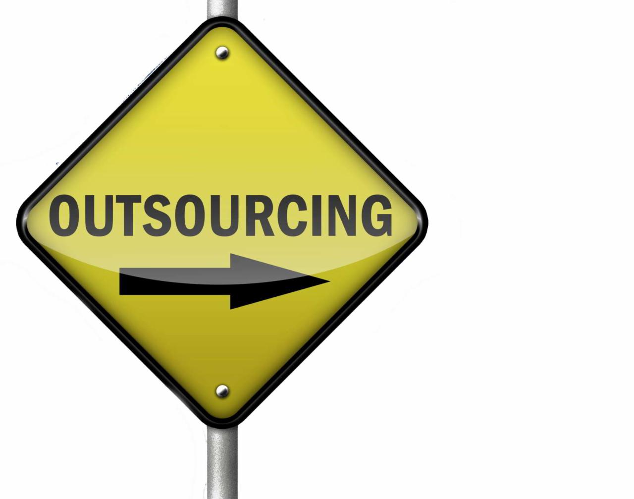 Żółty znak drogowy w kształcie rombu z czarnym obramowaniem i napisem 'OUTSOURCING' oraz strzałką w prawo, umieszczony na metalowym słupku.