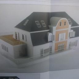 Bart- Bud - Model architektoniczny dwukondygnacyjnego domu z poddaszem, z balkonem i szarą dachówką, w odcieniach bieli i beżu, prezentowany na kartce papieru.