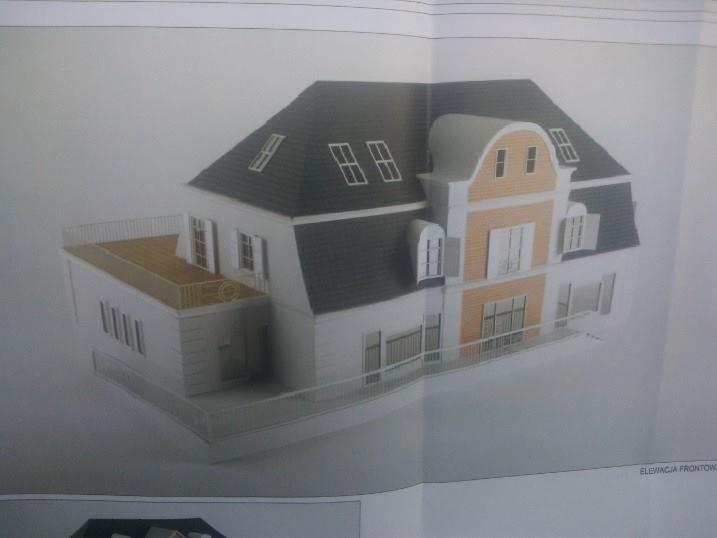 Model architektoniczny dwukondygnacyjnego domu z poddaszem, z balkonem i szarą dachówką, w odcieniach bieli i beżu, prezentowany na kartce papieru.