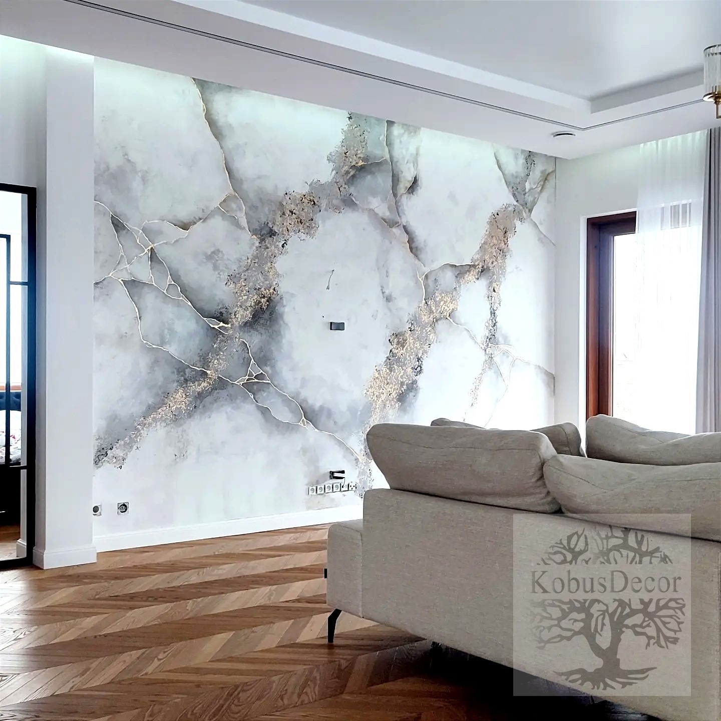 Eleganckie wnętrze z dekoracyjną ścianą imitującą marmur z złotymi żyłkami, parkiet w jodełkę, fragment sofy i subtelne oświetlenie.