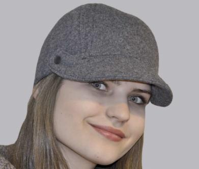 Portret kobiety z delikatnym uśmiechem, prezentującej szary, wełniany kaszkiet z małym guzikiem po boku.