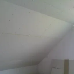 Płyty gipsowo-kartonowe zamontowane na poddaszu, widoczne łączenia i wkręty, przygotowanie do dalszych prac wykończeniowych.