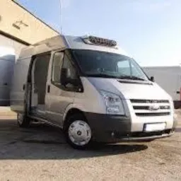 Srebrny bus dostawczy do 3,5 tony z otwartymi drzwiami bocznymi i agregatem chłodniczym na dachu, stojący na betonowym placu.