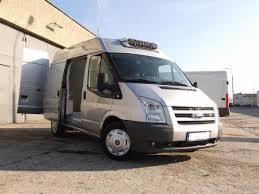 Srebrny bus dostawczy do 3,5 tony z otwartymi drzwiami bocznymi i agregatem chłodniczym na dachu, stojący na betonowym placu.