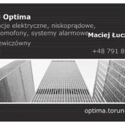 Wizytówka firmy F.H.U Optima z Torunia. Oferuje instalacje elektryczne, niskoprądowe, videodomofony i systemy alarmowe. Na dole grafika wieżowców.