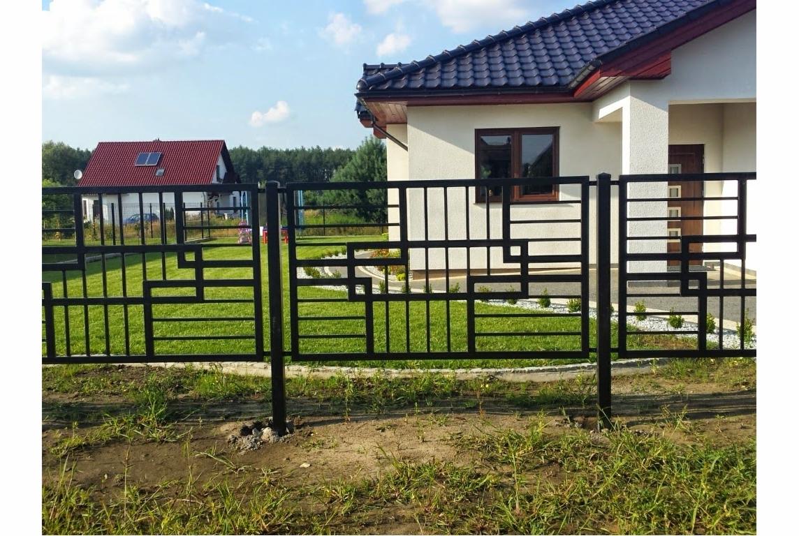 Nowoczesne ogrodzenie metalowe w kolorze czarnym z geometrycznym wzorem, na tle domu z ogrodem. Dobre oświetlenie, widoczna trawa i elementy architektury.