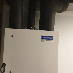 Centrala rekuperacyjna Komfovent Domekt z izolowanymi przewodami wentylacyjnymi w pomieszczeniu technicznym.