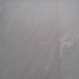 Szara, matowa okładzina ścienna z subtelnym wzorem, ułożona z precyzją. Widoczne delikatne fugi podkreślają regularny układ. Minimalistyczny design w neutralnej tonacji.