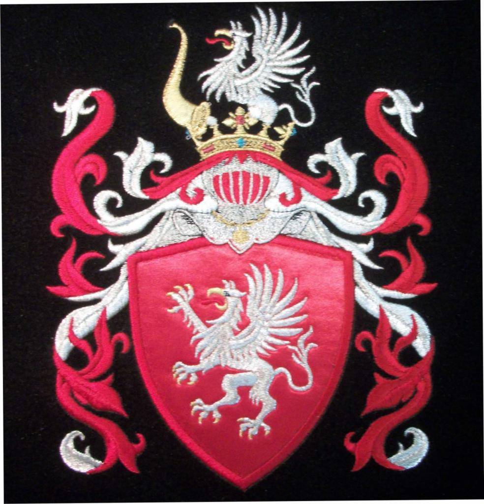 Wyszywany herb rodowy z czerwonym polem tarczy, srebrnym gryfem, koroną i ornamentami na czarnym tle.