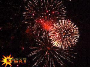 Eksplozja czerwono-złotych fajerwerków na nocnym niebie, z logo 'EFEKT' w lewym dolnym rogu, ukazane w dynamicznym ujęciu z dołu.