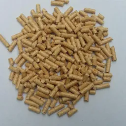 Jasne, drewniane pelety ułożone w nieregularny stos na gładkim, jasnym tle. Widoczne drobne struktury drewna i cylindryczny kształt.