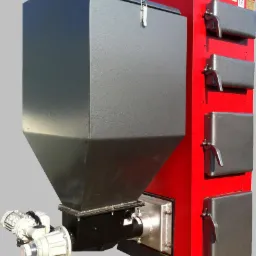 Nowoczesny, czerwono-szary piec na paliwo stałe z podajnikiem ślimakowym, widoczne drzwiczki rewizyjne. Detaliczny widok urządzenia grzewczego.